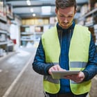 Image of man in safety vest looking at iPad