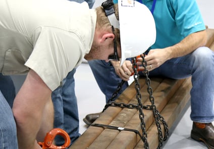 Image of man in hardhat working with chains